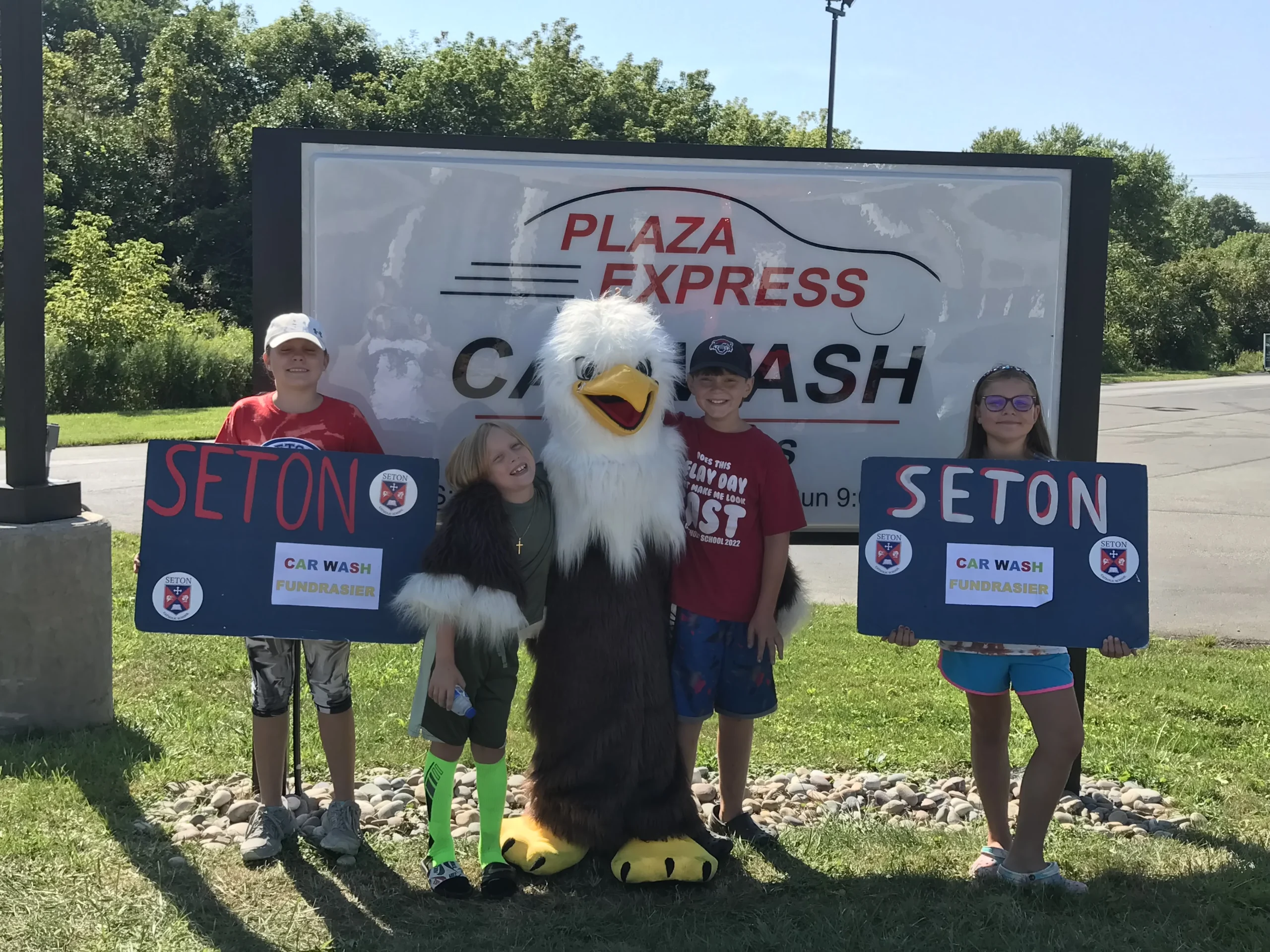 A group of people standing next to a large eagle.