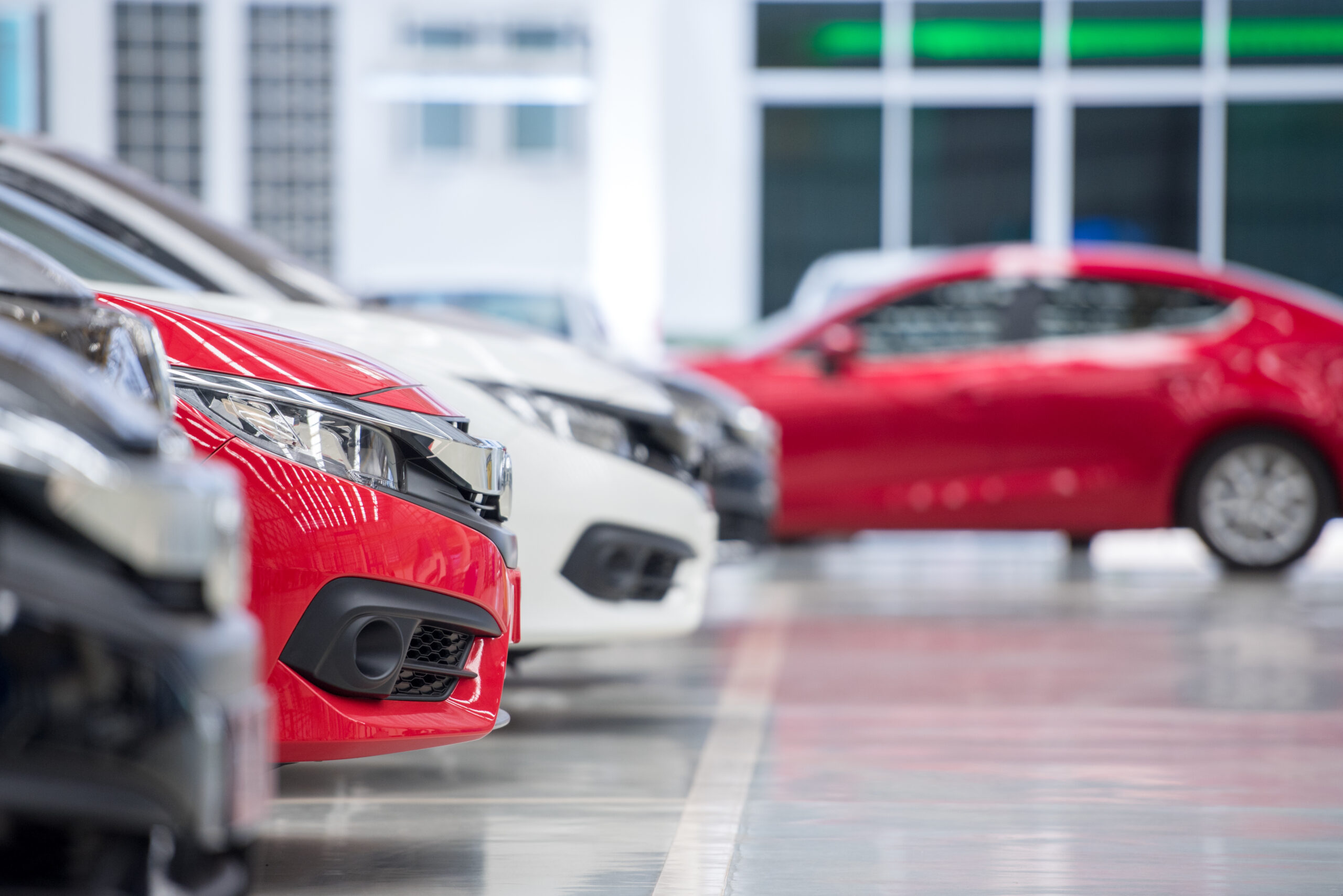 A row of red and white cars in a showroom.