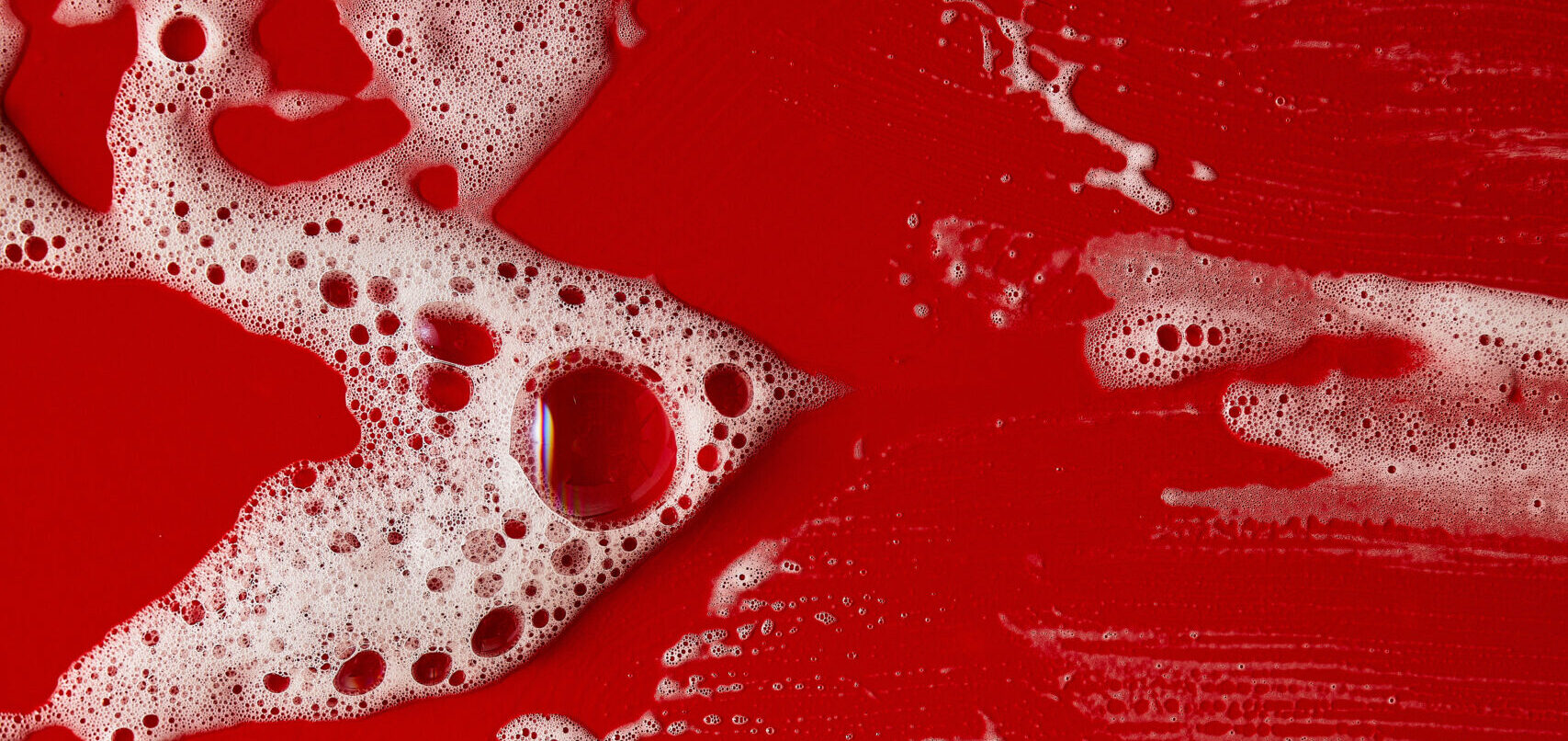 A red background with bubbles of liquid on it.